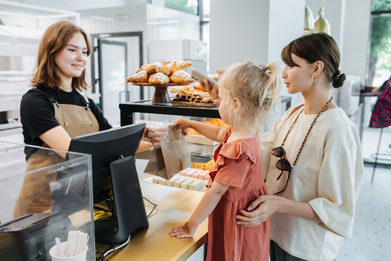 Mutter und Kind beim Einkauf an der Bäckereitheke
