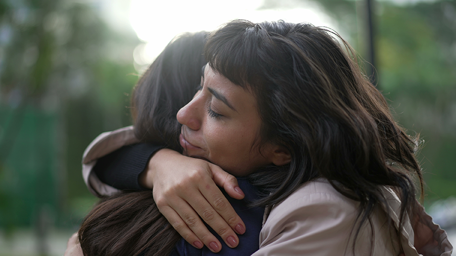 Zwei Frauen halten sich in einer innigen Umarmung