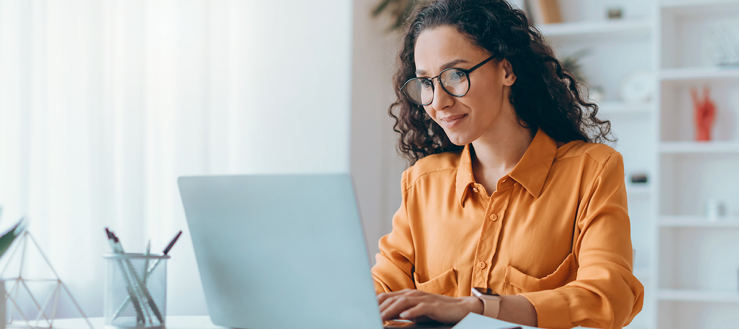 Frau arbeitet konzentriert am Laptop im hellen Büro