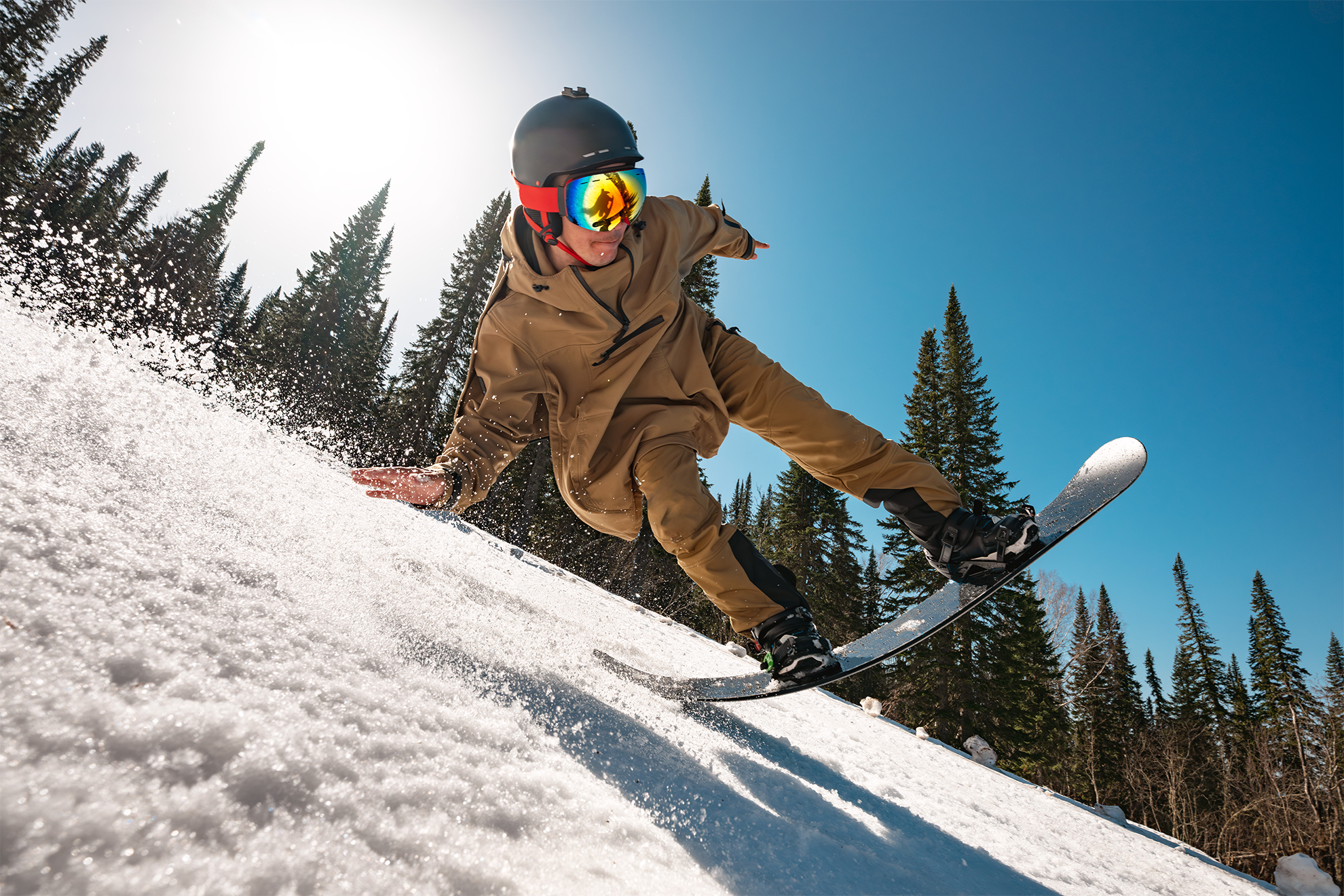Snowboarder in dynamischer Fahrt auf schneebedecktem Berghang