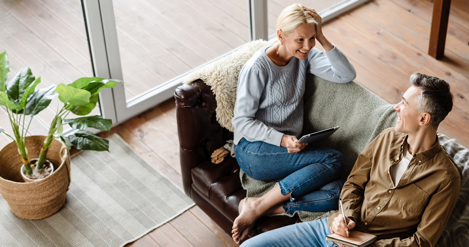 Zwei Personen sitzen entspannt auf einem Sofa und unterhalten sich