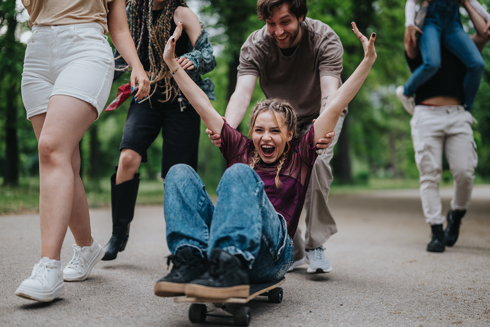 Jugendliche spielen ausgelassen mit einem Skateboard im Park